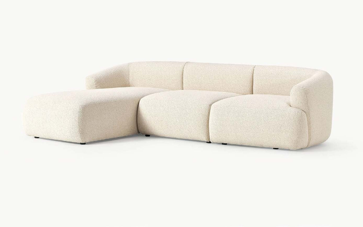 Colțar modular Elit în efect bouclé crem, cu module rotunjite, braț jos pe dreapta și șezlong pe stânga