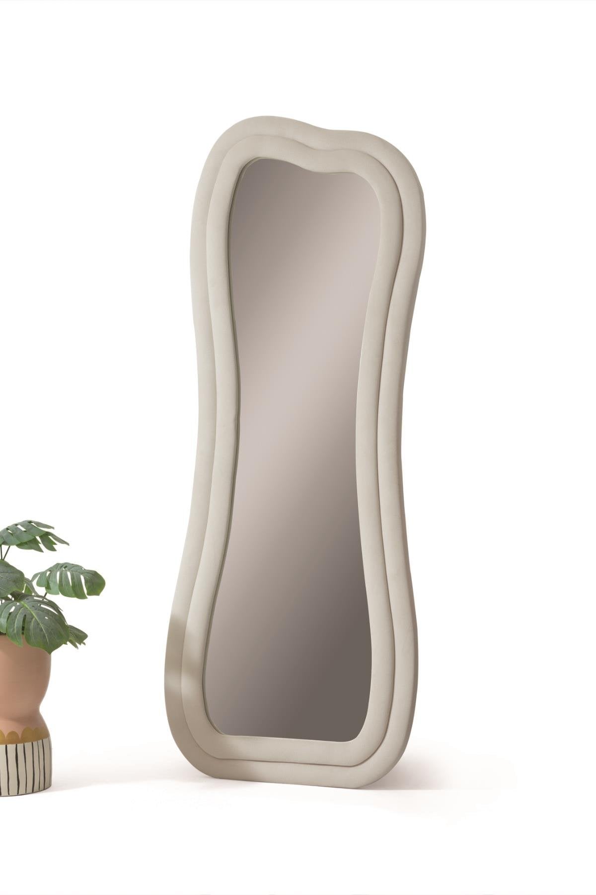Oglindă decorativă SWAN cu ramă ondulată bej-cenușiu și profil gros, model înalt de podea, lângă un ghiveci cu plantă