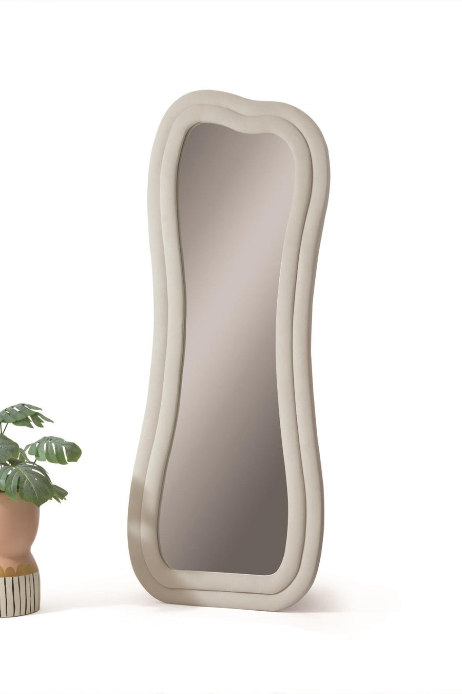 Oglindă decorativă SWAN cu ramă ondulată bej-cenușiu și profil gros, model înalt de podea, lângă un ghiveci cu plantă